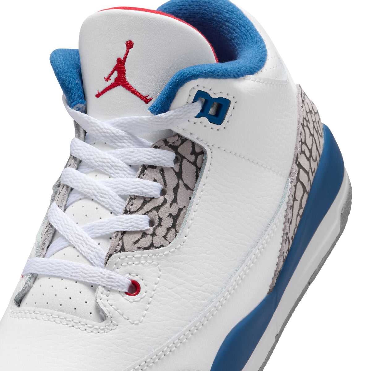 A close-up of a white Air Jordan sneaker featuring blue and red accents, with the Jumpman logo on the tongue and a gray elephant print on the side.