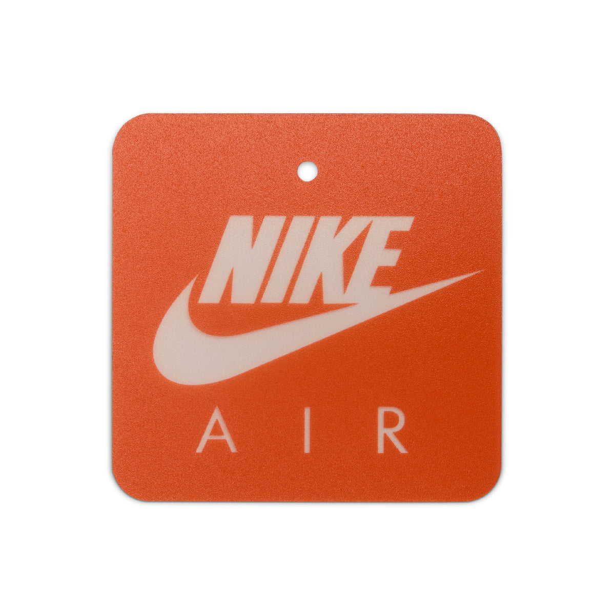 A square orange Nike Air fragrance tag with rounded corners, featuring a white Nike logo and swoosh, and the word 'AIR' printed below, on a white background.