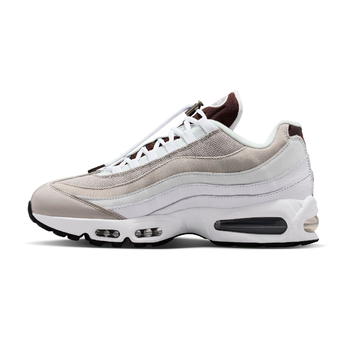 A Nike Air Max 95 sneaker in a colorway of light beige, white, and dark brown. The shoe features a beige and white wavy suede and mesh upper, white laces, and a white midsole with a visible dark brown Air cushioning unit.