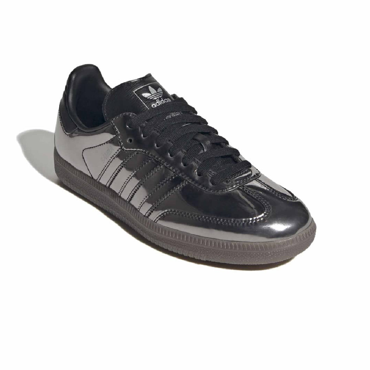A black Adidas Samba sneaker with glossy patent leather panels, black laces, and a dark gray sole, shown on a white background with a soft shadow.
