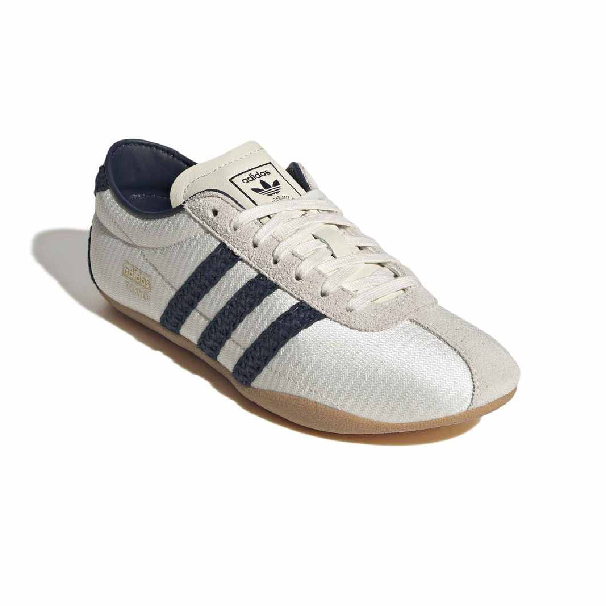 An Adidas Tokyo sneaker in off-white canvas with navy blue three-stripes, a navy blue collar, and a gum sole, shown on a white background with a soft shadow.