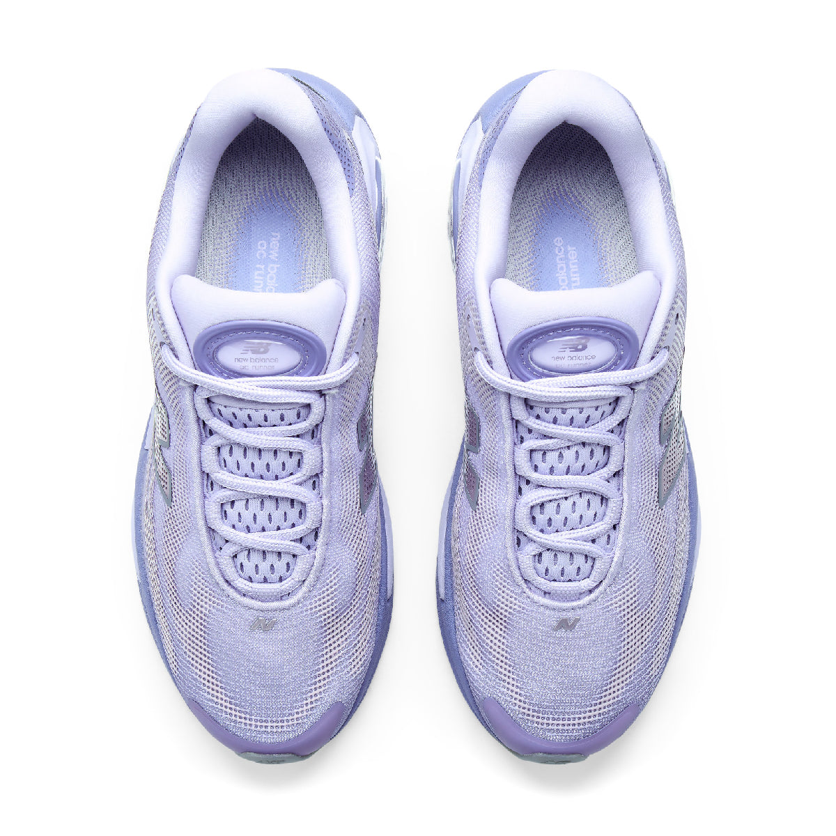 A pair of New Balance sneakers shown from a top-down view, featuring a light lavender and white colorway.