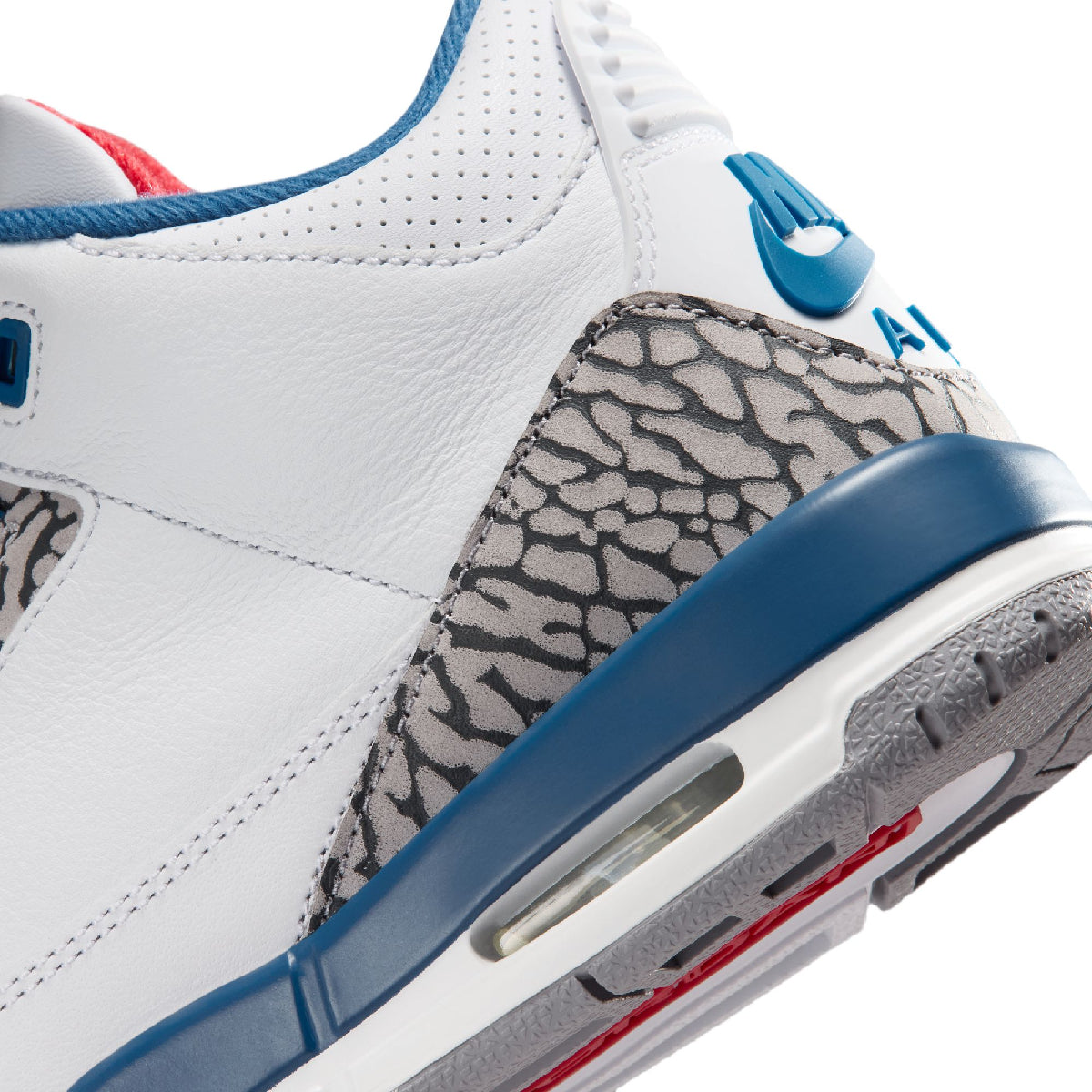 Close-up of a white leather sneaker with blue accents, a gray elephant print heel panel, and a translucent air unit, shown on a white background.