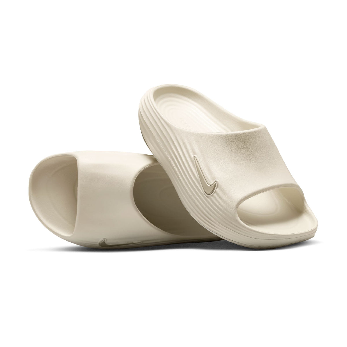 A pair of Nike slide sandals in a warm off-white or cream color, displayed on a clean white background.