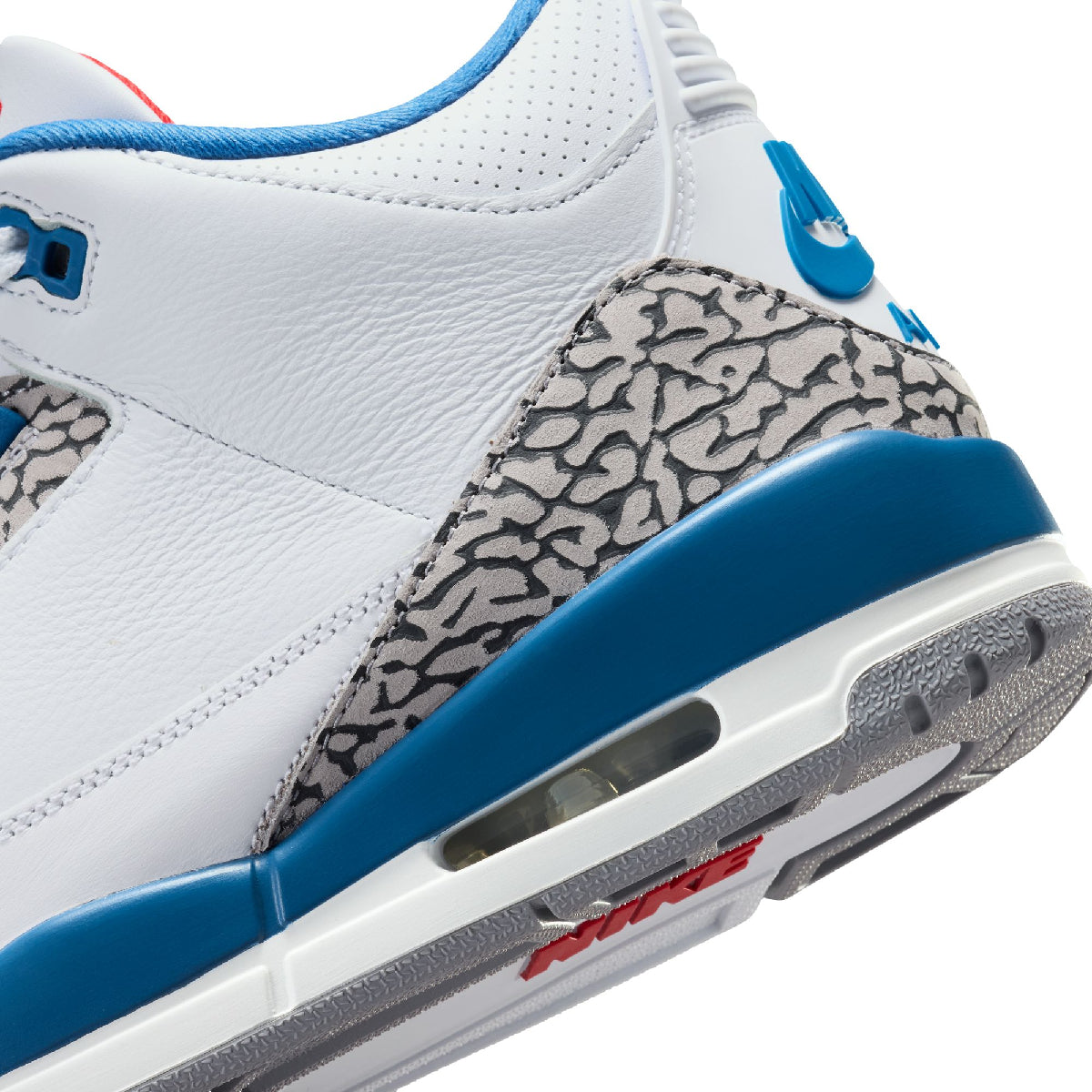 Close-up of a white leather sneaker with blue accents, a gray elephant print heel panel, and a white and gray sole on a white background.