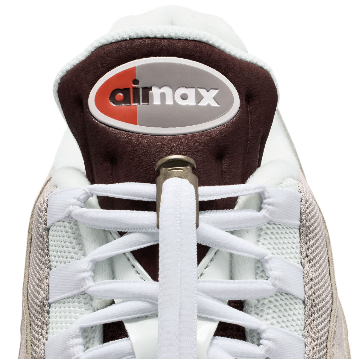 Close-up of the heel and laces of a Nike Air Max sneaker, showing the white and beige mesh upper, white laces, and the signature Air Max logo on the dark brown heel collar.