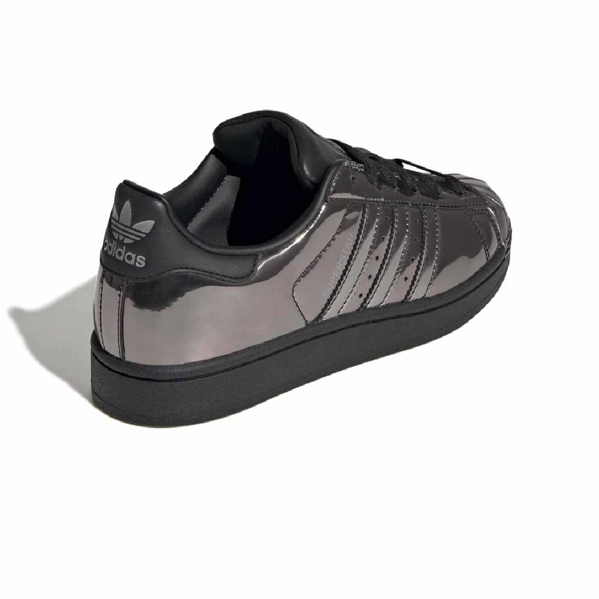 A low-top sneaker in glossy black patent leather with black laces and a dark gray rubber sole, shown from a three-quarters angle on a white background.