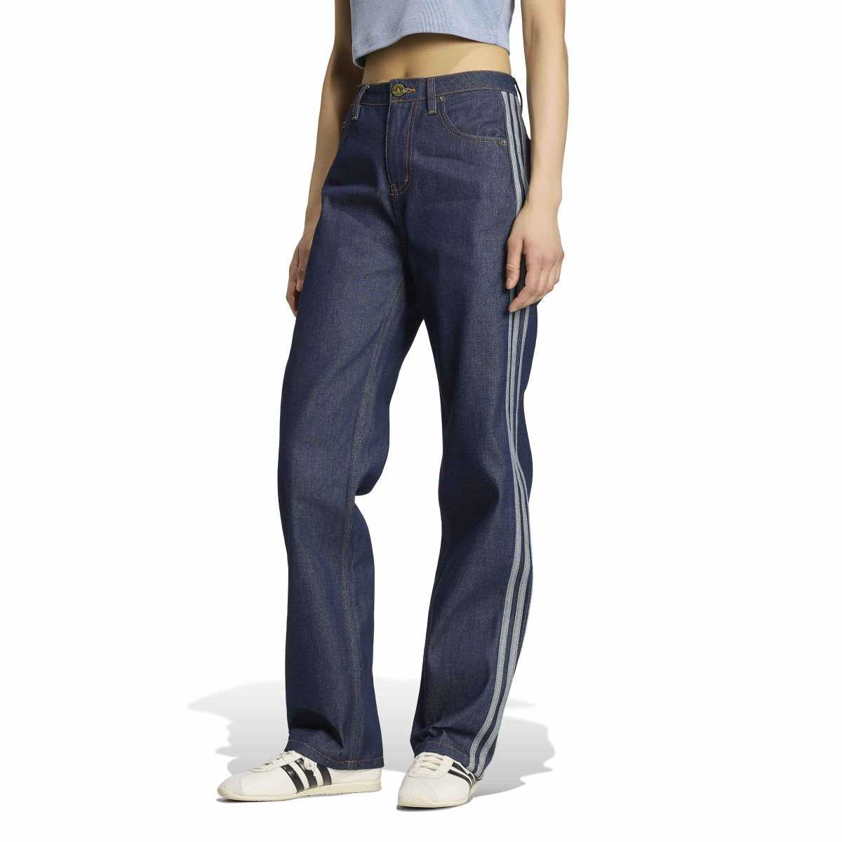 A model wearing a pair of dark blue wide-leg jeans with white side stripes, paired with white sneakers and a light blue crop top, shown from the waist down on a white background.