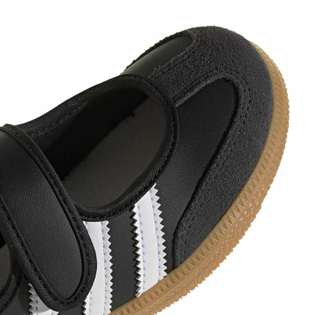 Close-up of a white and light gray sneaker with three green knit stripes and a gum sole, shown on a white background.