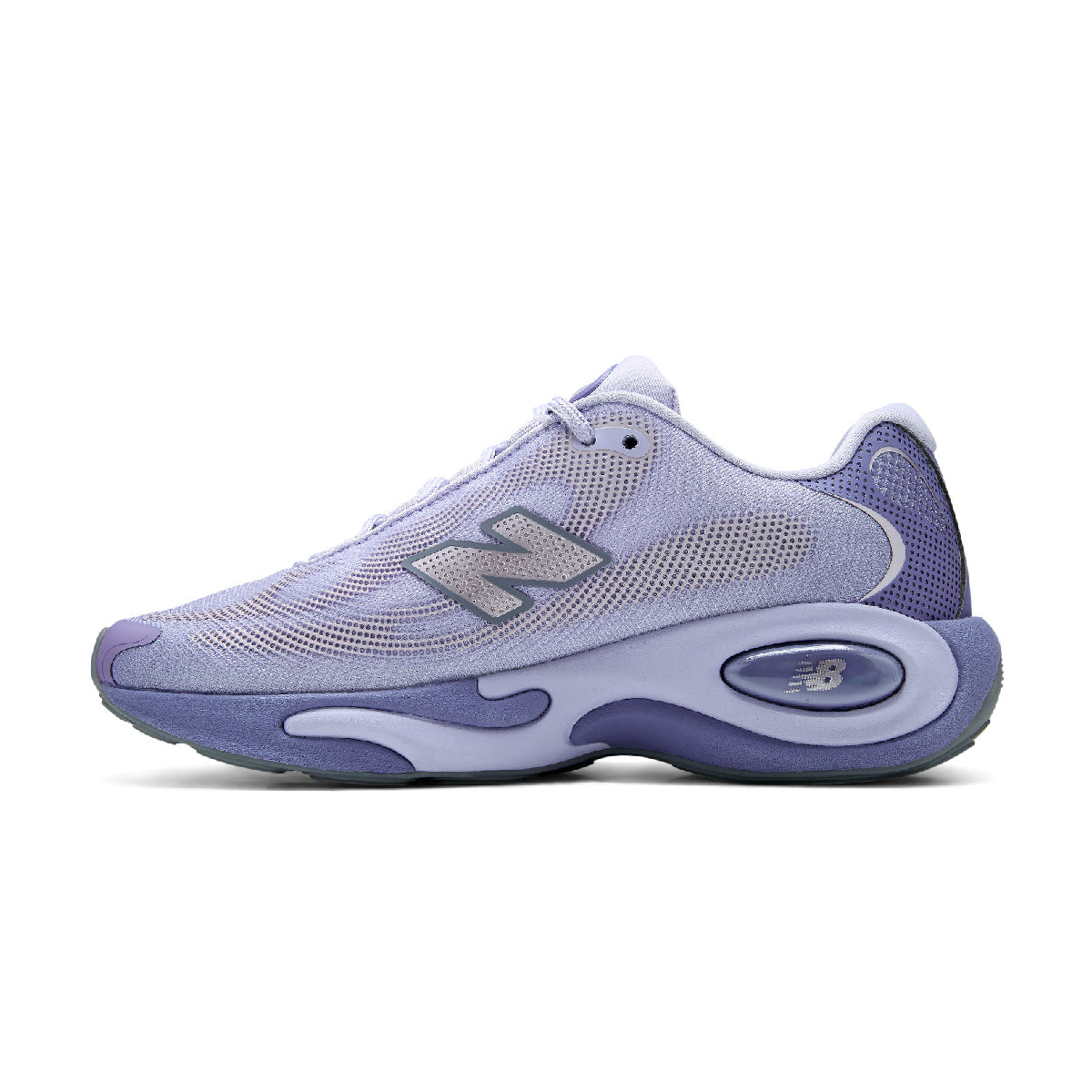 A New Balance sneaker in a light lavender and purple colorway, featuring a mesh upper, a metallic silver 'N' logo, and a thick sculpted purple and white midsole.