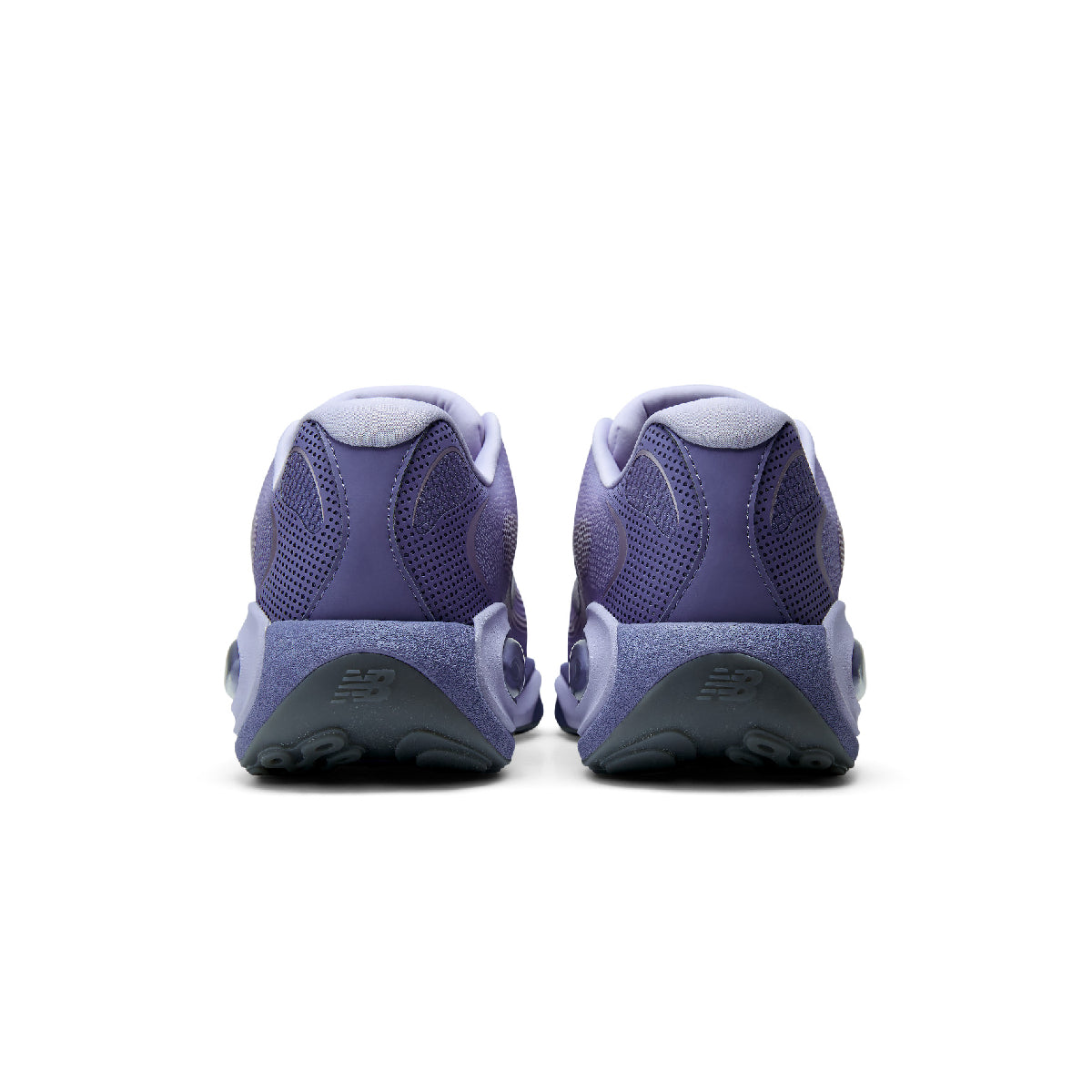 A pair of New Balance sneakers shown from the back, featuring a textured purple mesh upper and a chunky purple and gray midsole.